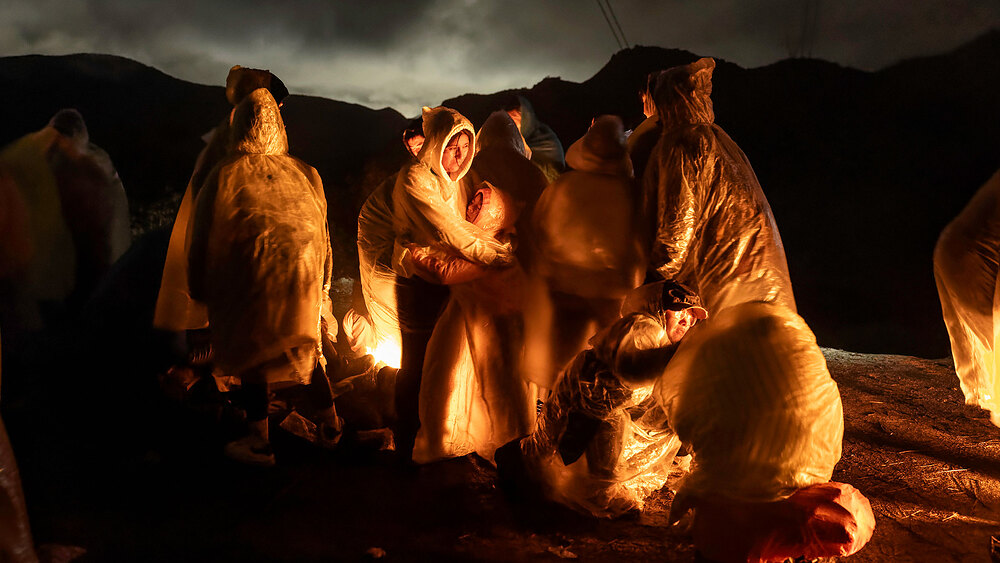 A Panoramic View Of The US-Mexico Border Migrants from China warm themselves in Campo, Calif., after crossing the U.S.-Mexico border in a rainstorm on March 6.