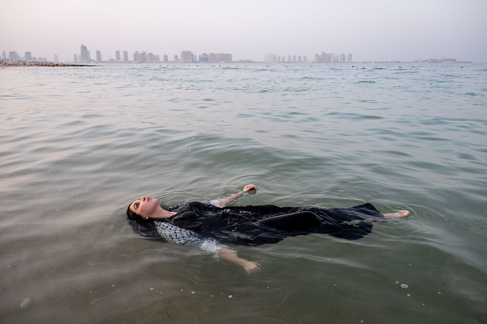 Layan Harouda, 15 years old, floats in the Persian Gulf off the coast of Qatar. She fled Gaza with her family in November and wonders if they will ever be able to return home. Doha, Qatar may 21st, 2024 Tanya Habjouqa