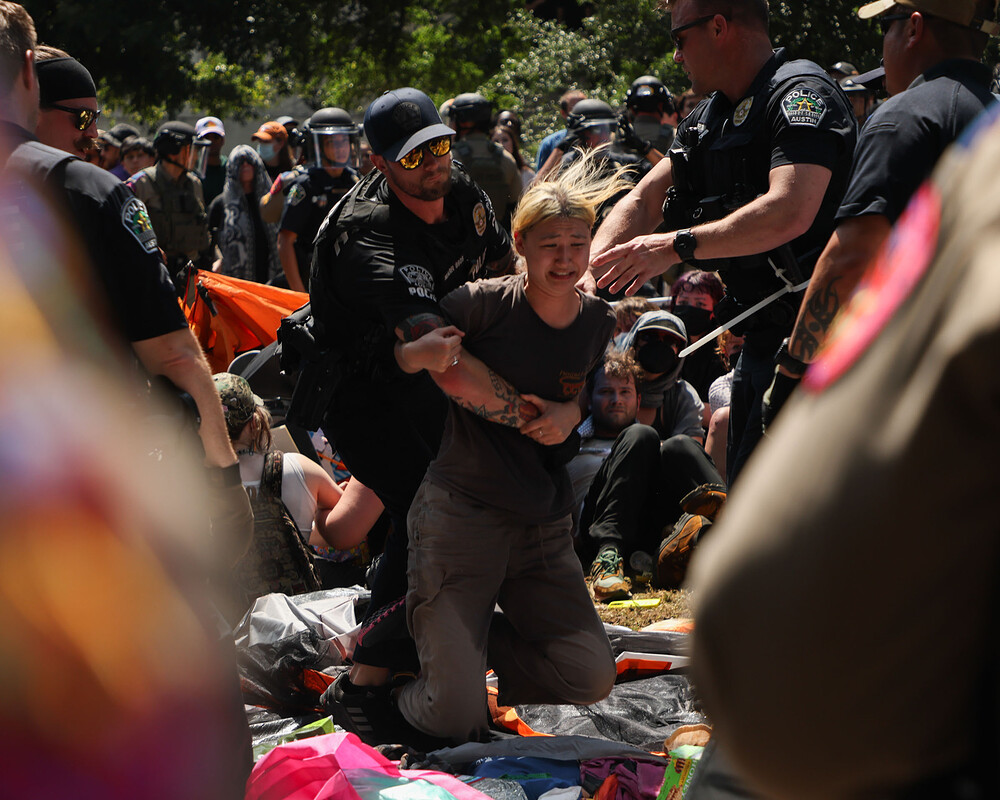 Police grab a protester as they break up an encampment on the University of Texas campus
