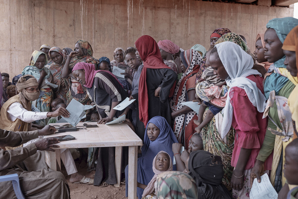 Sudanese women and children register with Chadian authorities upon arrival in Adre, a border town in the Ouaddaï province. According to UNHCR, the conflict in Sudan has forced over 600,000 refugees and 180,000 Chadian returnees since April 2023. Most of them, women and children, fled into Chad, with more than 115,000 arriving since the start of 2024. This influx shows no signs of abating, with an average of 630 people crossing the Adre border daily over the last month. They are fleeing for their lives from a devastating war that is driving famine-like conditions in Sudan. Overcrowded and unsanitary conditions in Adre have led to a severe health crisis, with over 1,200 cases of Hepatitis E reported, including three fatalities. The impending rainy season, expected between June and September, threatens to exacerbate this crisis, with fears of waterborne diseases such as cholera and impeding humanitarian access. Chad, 2024.